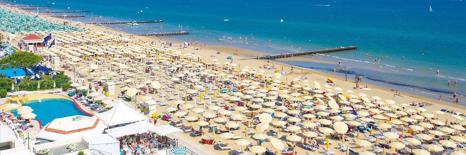 Lido di Jesolo, which is lined with parasols , and where many people take a swim in the turquoise Mediterranean Seasea.