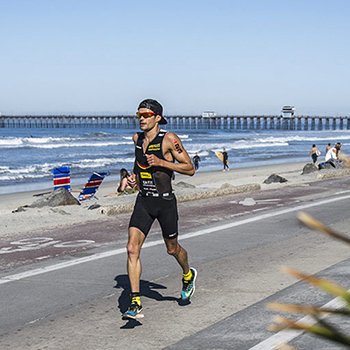 Triathlete running near the ocean at IM703 Oceanside