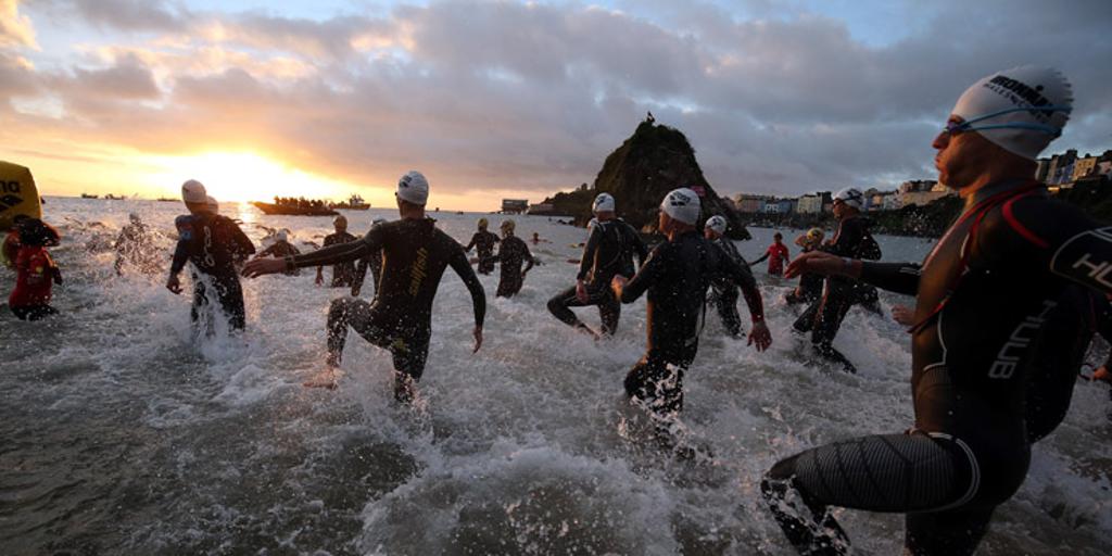 Triathletes entering water for swim