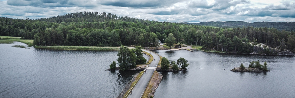 Bird's eye view of IRONMAN 70.3 Jönköping course showing athletes biking on the road between the lake