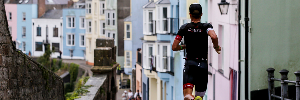 IRONMAN Wales athletes running through the medieval town walls and picturesque beachfront 