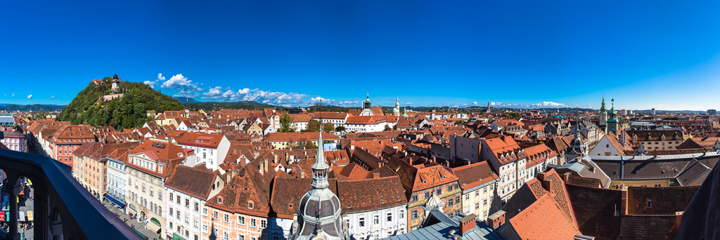 Fisheye photography of the Old Town of Graz with views of the Schlossberg and famous Clock Tower on a cloudfree and sunny day