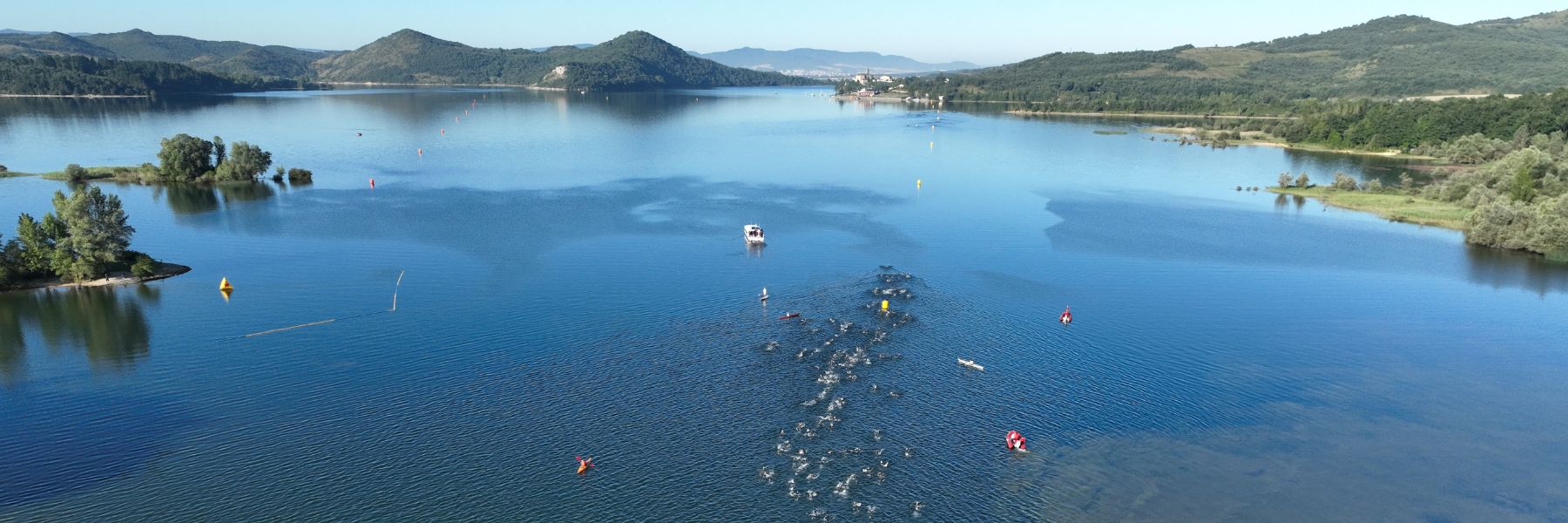 IRONMAN Vitoria-Gasteiz athlete standing in Ulibarri-Gamboa lake located in the Landa Provincial Park who is looking around and ready for the swim