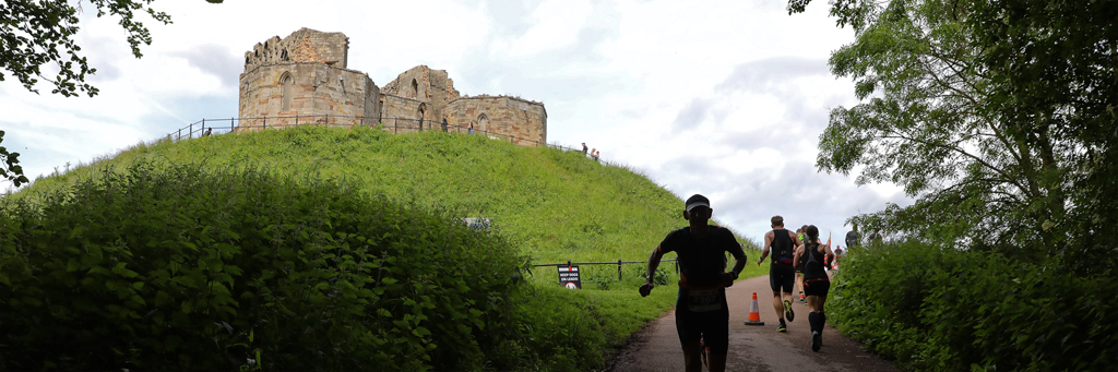 Athletes running through some shady forests towards Stafford Castle at  IRONMAN 70.3 Staffordshire
