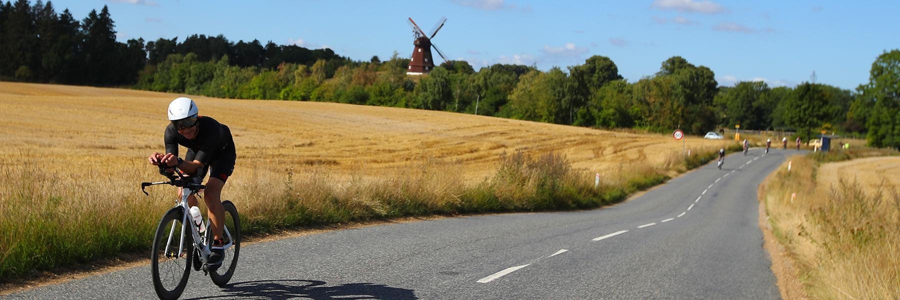 IRONMAN Copenhagen athlete biking through the green countryside in Denmark