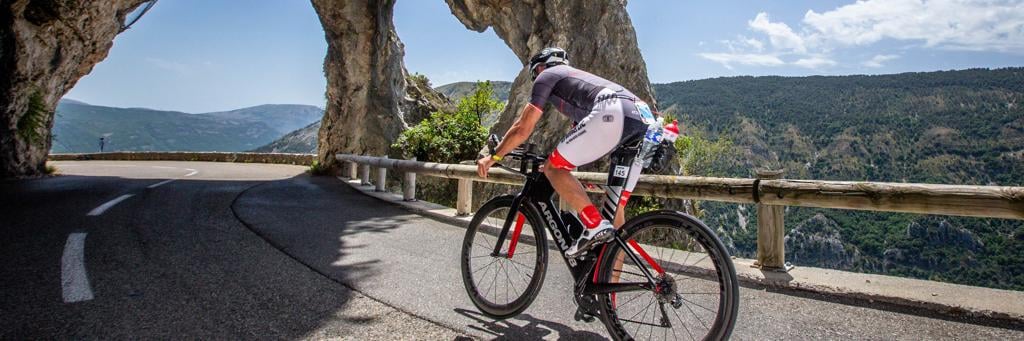 IRONMAN France Nice athlete bike riding through a breathtaking mountain cave view at IRONMAN France Nice