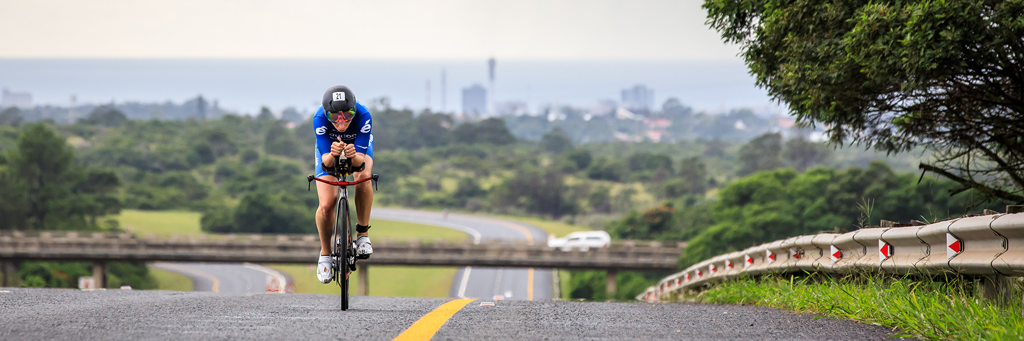A single IRONMAN 70.3 South Africa athlete on his bike taking on the rolling hills towards the city in Buffalo City, East London
