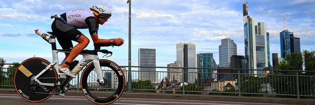Athlete biking with an impressive skyline of Frankfurt in the background