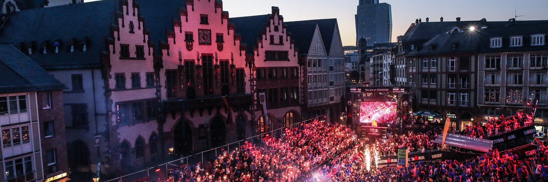 Magic finish line with little fireworks and balloons and  hundreds of people viewing and cheering on the athletes on the grandstands of the famous Römer in the city center of Frankfurt