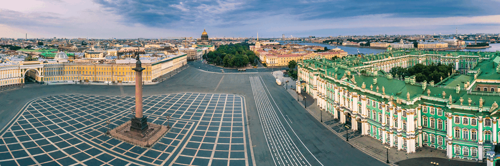 Wide angle image of green-and-white Winter Palace and Alexander Column on Palace Square next to Neva River and other buildings of St. Petersburg, Russia