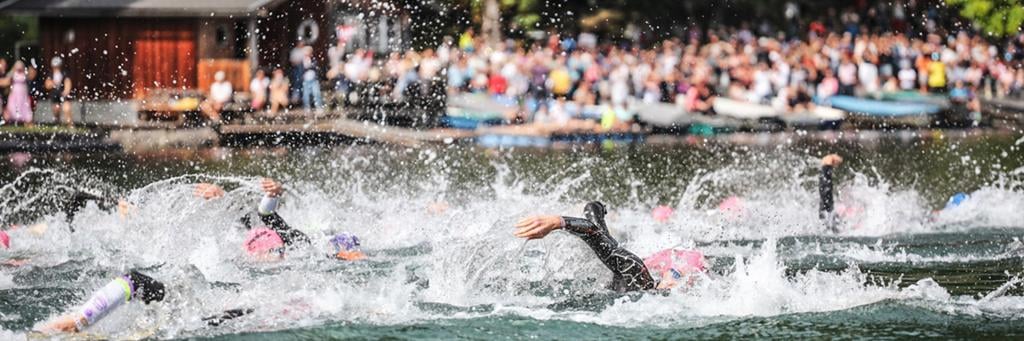 IRONMAN 70.3 Zell am See-Kaprun athletes swimming in lake Zell with the water splashing around