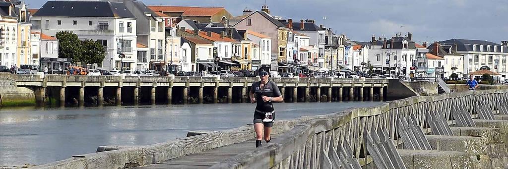 Athletes are running along the Tanchet lake on the famous promenade of Sables d’Olonne 