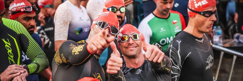 Two athletes pointing at the camera being ready for the swim start at IRONMAN 70.3 Oman
