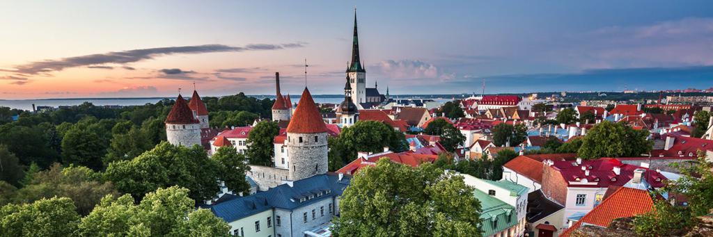 Scenic view of Tallinn's Old Town with Olaf's church and Walls of Tallinn next to more buildings and views of parks and the sea