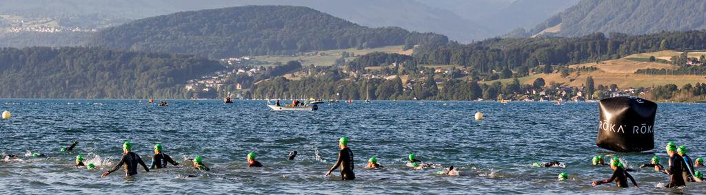Athletes swimming in the lake at IRONMAN Switzerland Thun, where they are surrounded by the majestic Swiss Alps