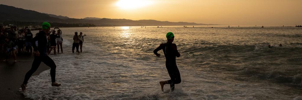 IRONMAN 70.3 Marbella athletes are about to run into the Mediterranean sea for the swim at sunrise