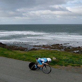 An athlete on his bike near the raging sea at IRONMAN Wales