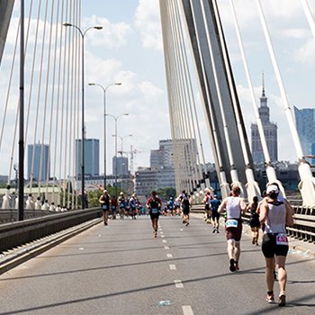Athletes running on race day over a bridge in Polish Warsaw at 5150 Warsaw