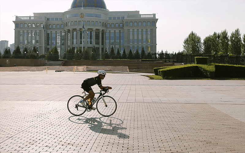 IRONMAN Kazakhstan Support - Picture of an athlete biking on a town square