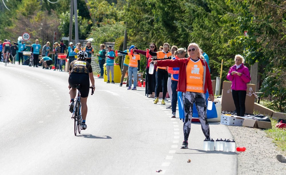 Volunteers geben Wasser an Athleten aus beim IRONMAN Tallinn