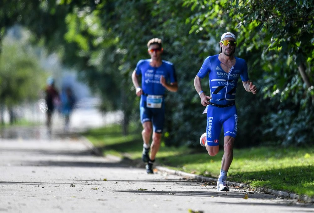 Two athletes running behind each other in a park at IRONMAN Gdynia